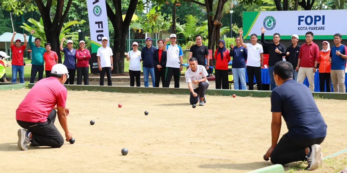 Petanque di fopikotaparepare.org dengan pemain beragam dan suasana ceria di taman olahraga.